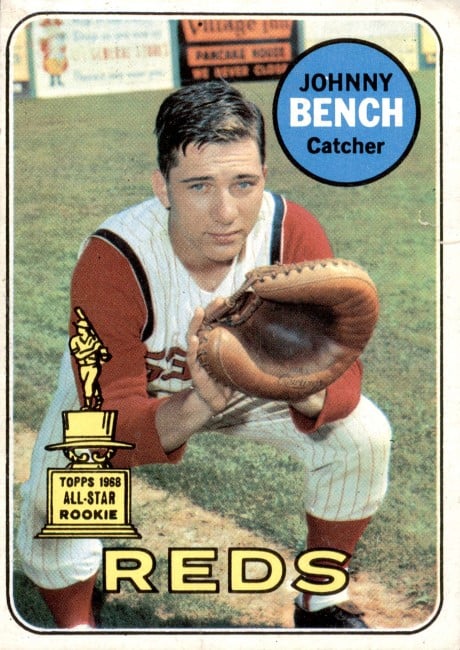 Close-up photo of a 1969 Topps baseball card with young Johnny Bench in a catching pose, wearing a Cincinnati Reds uniform. Rookie Card (#95)